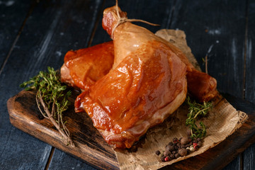 Smoked chicken legs on a wooden board, rustic style
