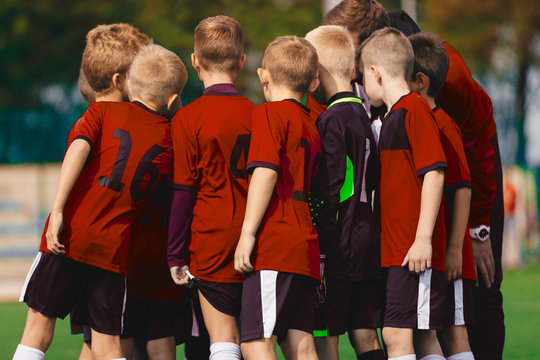 Youth Soccer Coach Coaching Boys Team. Soccer Team With Coach in Red Jersey Shirts - Powered by Adobe