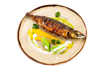 Plate of grilled mackerel fish served with sauce isolated at white background.