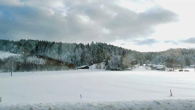 Driving on a highway in winter time and observing a beautiful nature. The sky is blue. It's a beautiful day.