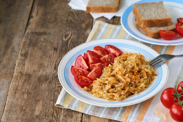 Stewed cabbage with fresh cherry tomatoes on a plate 