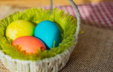 Obraz na płótnie Canvas Three Easter eggs in a basket.