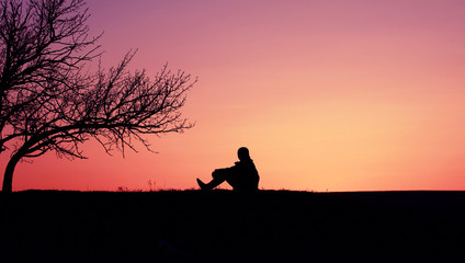 Silhouette of a boy child against the backdrop of a beautiful sunset.