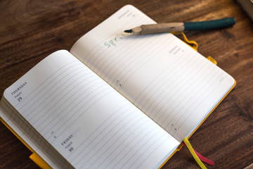 Open diary with pen on wooden table