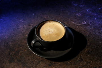 cup of coffee on black background top view