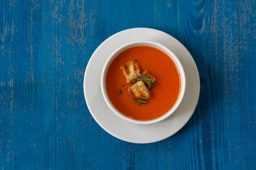 Bowl of  tomato soup on the blue table