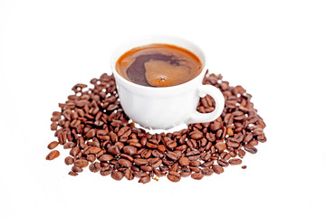 Coffee beans scattered around a cup of coffee.