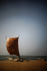 Einsames Boot am Strand mit Wind im Segel