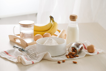 Fototapeta na wymiar ingredients and tools to make banana cake on white background