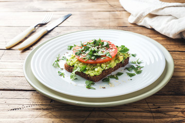 Avocado toast. Healthy toast with avocado mash and tomatoes on a plate.