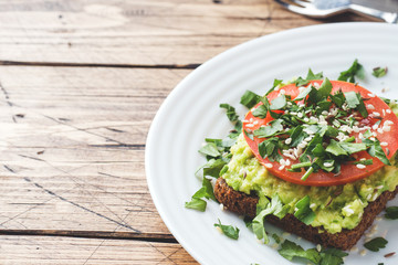 Avocado toast. Healthy toast with avocado mash and tomatoes on a plate.