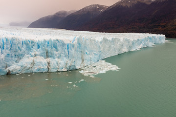 The the face of the Perito Moreno Glacier located in the Los Glaciares National Park in Santa Cruz Province, Argentina. With the autumn tree colours in the foreground