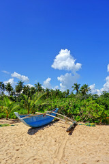 Paradiesischer Strand mit Palmen und Boot in Tangalle (Sri Lanka)