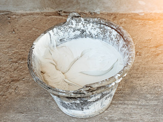 Mixing plaster solution in a bucket in construction site