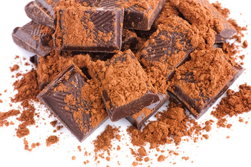 Broken dark chocolate with cocoa powder