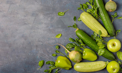 The layout of green vegetables on a dark background.