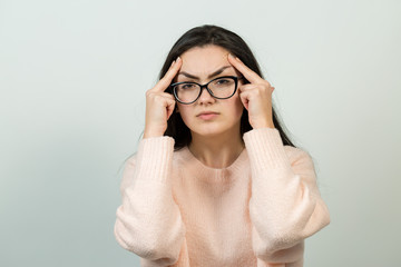 Emotional portrait of a dark-haired girl on a gray background, stormy emotions, business concept.	