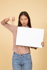 Fototapeta na wymiar Young Asian woman show thumbs down with white blank sign.