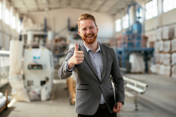 Businessman in a factory. Manager shows thumb up. 