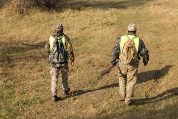 Hunter with a german drathaar and spaniel, pigeon hunting with dogs in reflective vests	