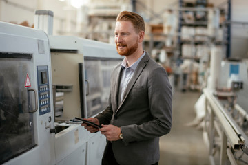Manager checks machines at the factory.  Inspector checks a factory.  Supervisor runs his daily check at work. Factory worker setting the tech up for work.