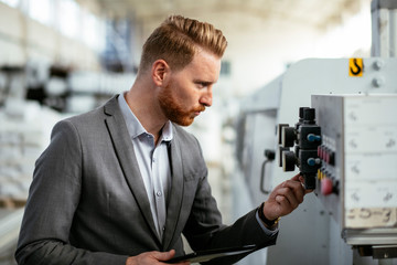 Manager checks machines at the factory.  Inspector checks a factory.  Supervisor runs his daily check at work. Factory worker setting the tech up for work.