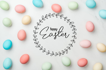 top view of multicolored chicken painted eggs on grey background with happy Easter lettering in circle frame