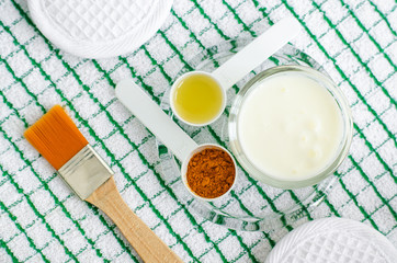 Greek yogurt (sour cream or kefir) facial mask with turmeric powder and olive oil. Ingredients of diy face and hair masks and moisturizers. Homemade beauty treatments recipe. Top view, copy space 