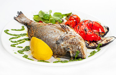 Fried tilampia on a dish with vegetables.