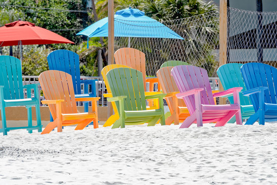 Colorful Adirondack chairs on the beach