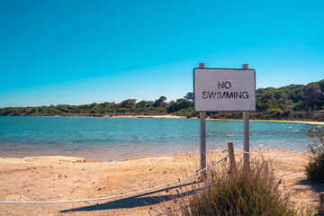 Lake. No swimming sign. Unsafe waters. Summer holidays. 