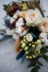 Obraz na płótnie Canvas bridal bouquet of roses and cotton flowers in the snow