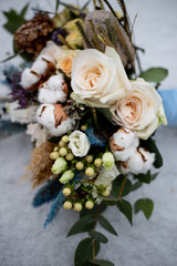 bridal bouquet of roses and cotton flowers in the snow
