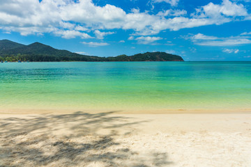 Fototapeta na wymiar White sandy tropical beach with blue lagoon on sunny day