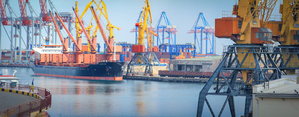 Lifting cargo cranes, ships and grain dryer in Sea Port of Odessa, Black Sea, Ukraine. Work of the container terminal for shipping goods.