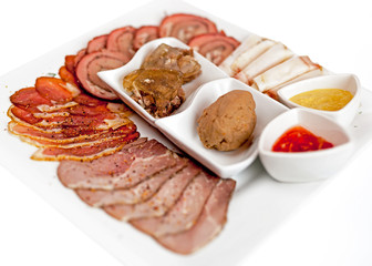 A plate with meat dishes, kebabs, bishtex, sauces and various croutons.