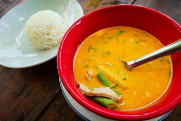 Thai yellow curry soup with rice on rustic table