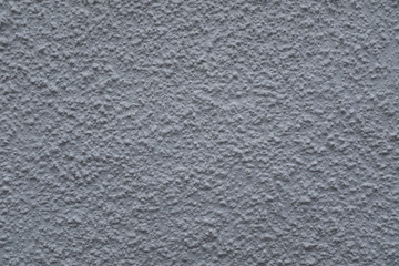 A close up photo of an exterior  textured wall painted gray textured, surface with stucco daub,...