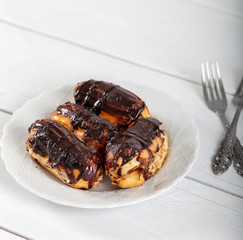 Ekler Pasta / Chocolate Donut in plate on white background.