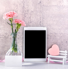 Home decor with blooming carnation and tablet as photo frame beside wall on the table - Close up,...