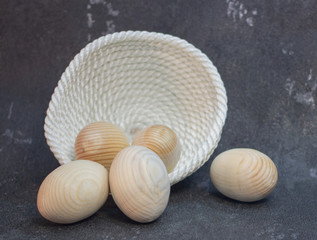 Decorative wooden Easter eggs in a wicker plate basket