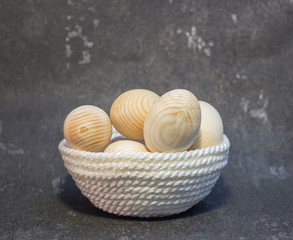 Decorative wooden Easter eggs in a wicker plate basket