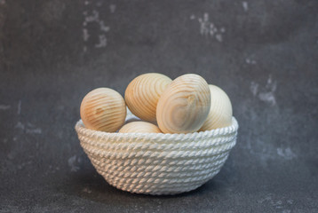 Decorative wooden Easter eggs in a wicker plate basket