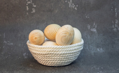 Decorative wooden Easter eggs in a wicker plate basket