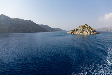 Mediterranean sea overlooking the mountains. Aerial top view of sea waves hitting rocks on the beach with turquoise sea water. Amazing rock cliff seascape in the coastline.