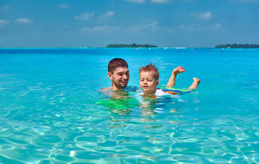 Toddler boy learns to swim with father