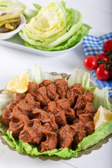 Turkish Food Cig Kofte with lemon, lettuce and parsley on silver plate