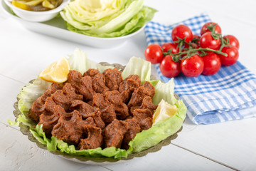 Turkish Food Cig Kofte with lemon, lettuce and parsley on silver plate