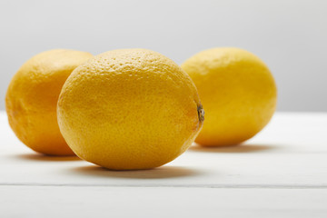 ripe organic lemons on white wooden table isolated on grey