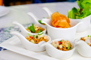 Thai appetizer, fired pork with herbs served on spoon 
